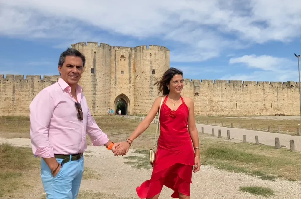 Photographie de diegoenfrance.com : couple marchant vers les remparts historiques d’Aigues-Mortes, une icône du tourisme en Camargue