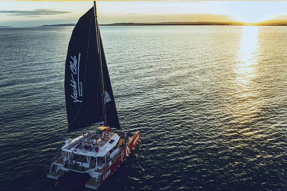 catamaran naviguant au coucher du soleil sur la côte camarguaise, près d’Aigues-Mortes.