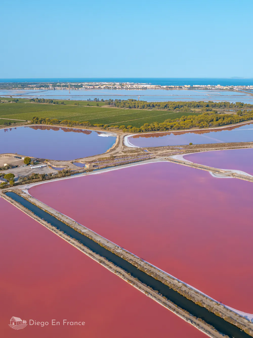 Tourisme à Aigues-Mortes. Vue aérienne des marais salants roses, destination incontournable de la Camargue. Photo par diegoenfrance.com