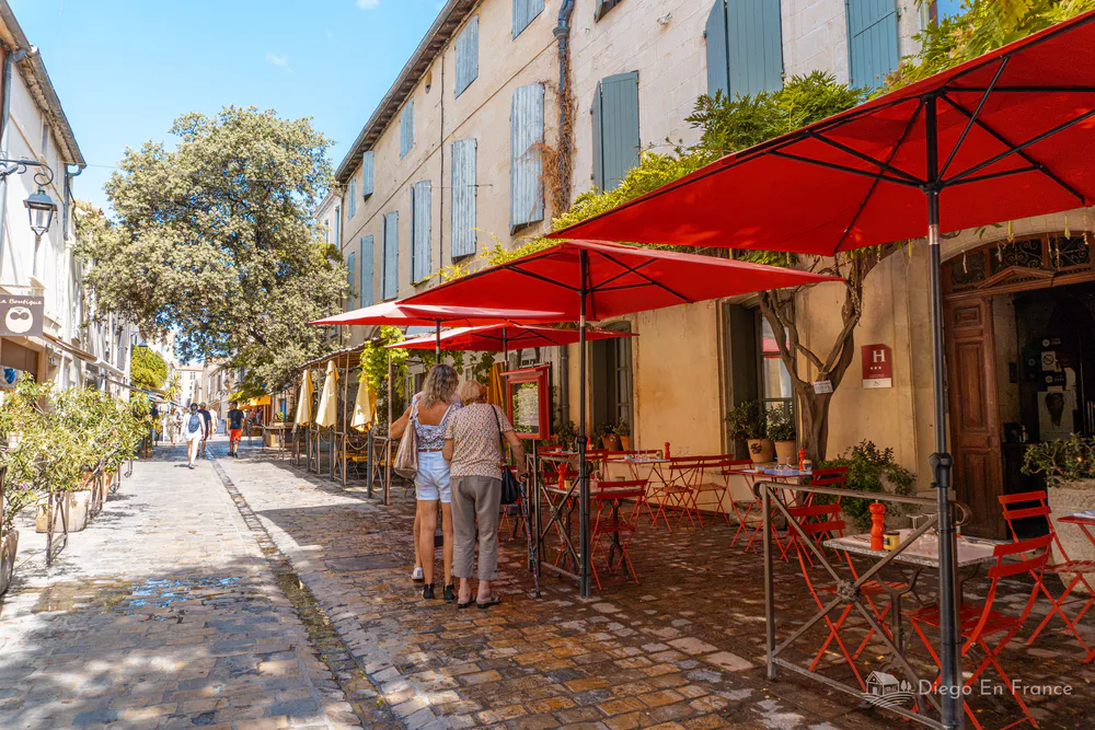 Photographie de diegoenfrance.com : restaurant avec terrasses rouges et rues pavées à l’intérieur des remparts d’Aigues-Mortes.