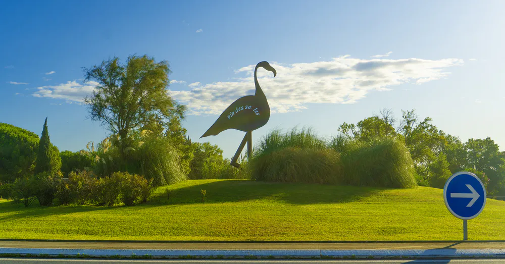 Rond-point avec sculpture de flamant rose, entrée symbolique de la ville d'Aigues-Mortes en Camargue. Photo par diegoenfrance.com
