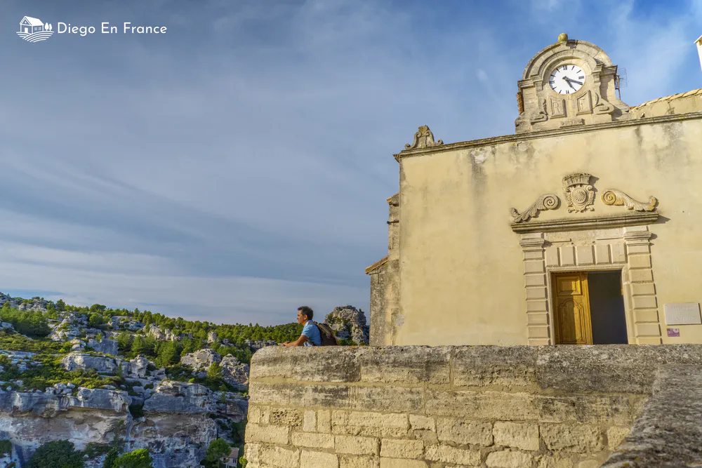 Fotografía de diegoenfrance.com de un viajero apoyado en un muro contemplando el paisaje desde la capilla de Les Baux al atardecer