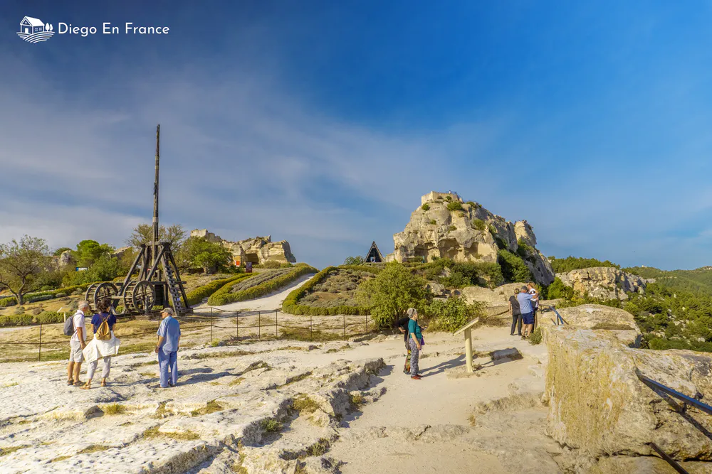 Fotografía de diegoenfrance.com de un trébuchet y las ruinas del castillo, ideal para visitar les Baux de Provence con niños