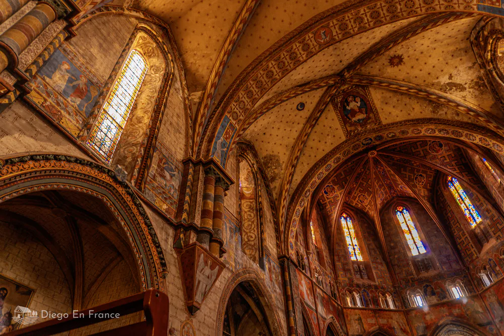 interior iglesia notre dame du bourg rabastens frescos medievales vitrales coloridos
