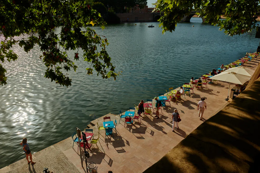 Colorful chairs in front of the river, one of the best ways to enjoy what to see in Toulouse at your leisure