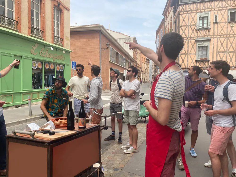 Guide explaining details during a gastronomic tour in Toulouse, to discover French cuisine and culture through authentic flavors.