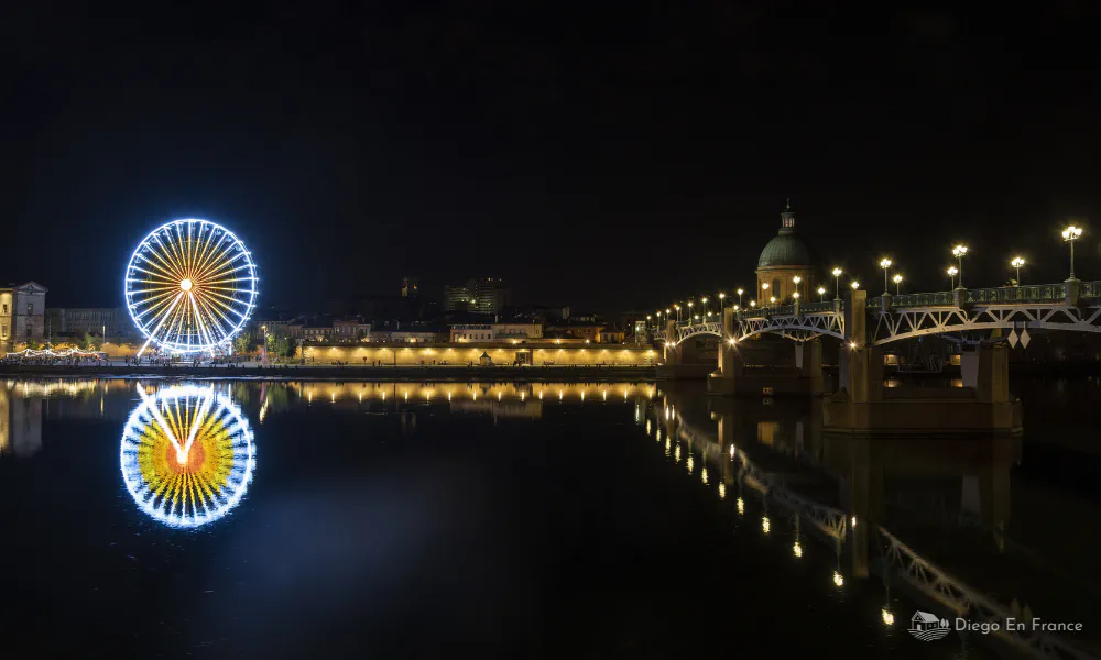 Reflection of the Ferris wheel and the bridge over the Garonne river, a magical scene to do in Toulouse at night