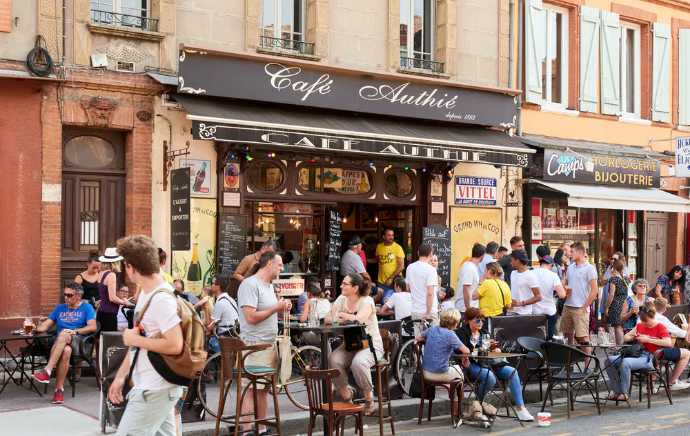 Street atmosphere in front of the Café Authié, ideal for a typical apéro among the best things to see in Toulouse.