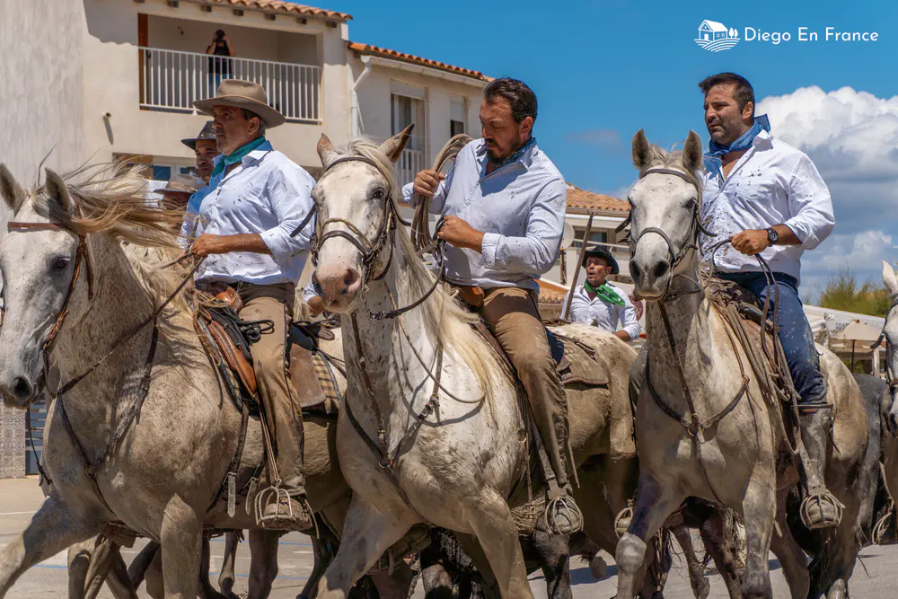 Photographie de diegoenfrance.com d’un abrivado au cœur du village avec des cavaliers camarguais à cheval