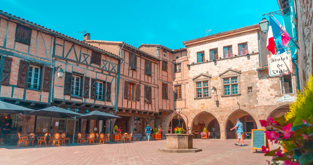 Historic town square with half-timbered facades and typical cafes.