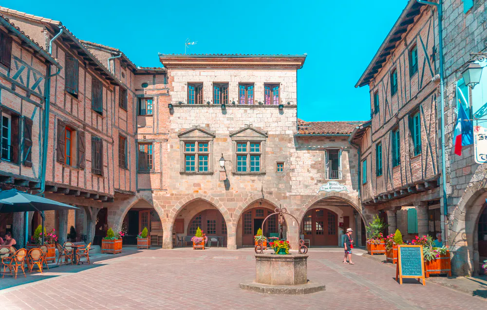 Main square of the village with medieval arcades and cozy atmosphere, an essential place to visit.