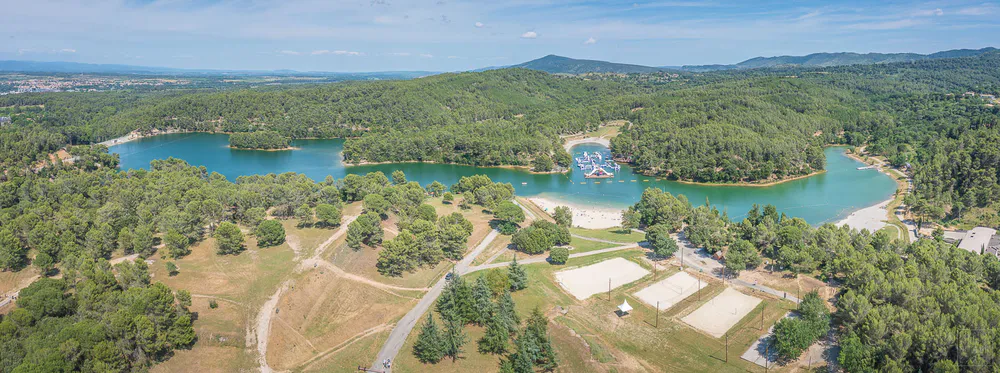 Panorámica del Lac de la Cavayère con áreas de playa, bosques y actividades acuáticas, destino ideal para familias