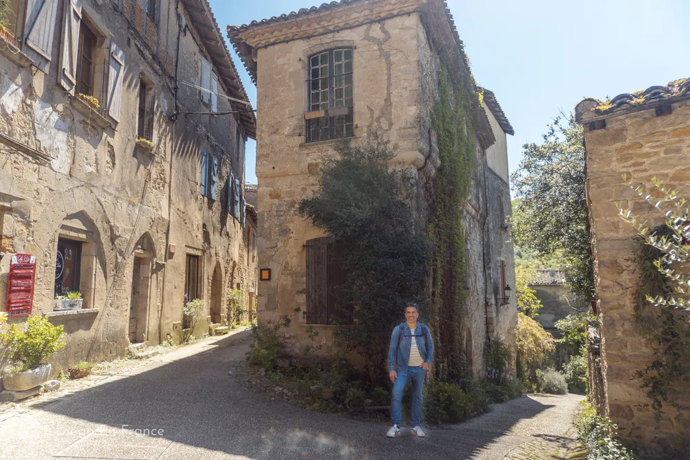 Tourist exploring the charming old town of Bruniquel, a medieval jewel to discover on an excursion from Toulouse.