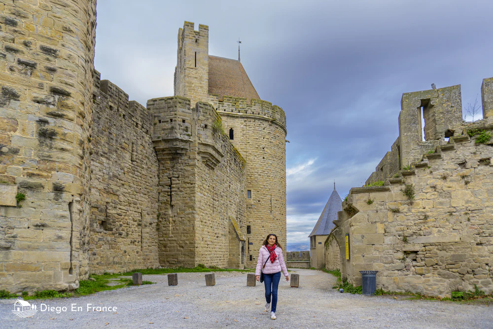 Tourist walking inside the medieval fortress of Carcassonne, one of the best day trips from Toulouse. Photo by diegoenfrance.com
