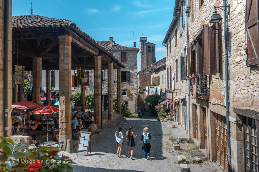 Cordes-sur-Ciel's central square with its wooden market and terraces, a perfect place to enjoy the South of France with the family