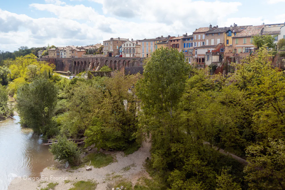 View of the old town of Rabastens from the Tarn river, surrounded by greenery, perfect for a quiet getaway from Toulouse. Photo by diegoenfrance.com 