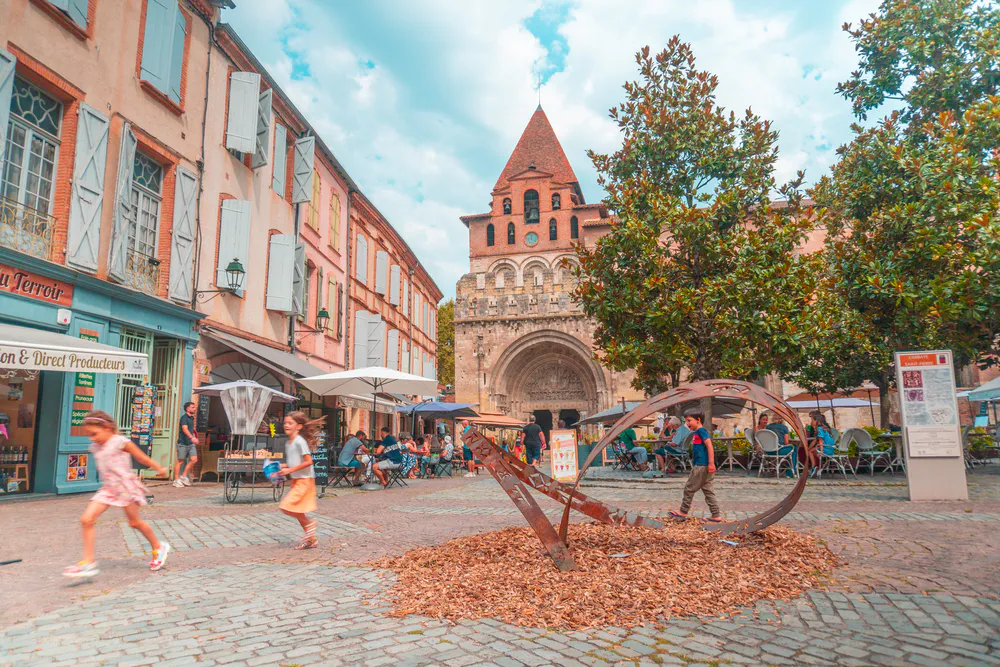 Plaza central de Moissac con vista a la abadía y esculturas al aire libre