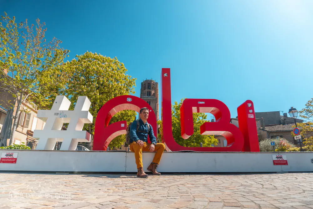 Tourist next to the #Albi sign with the cathedral in the background, on one of the most photogenic excursions from Toulouse. Photo by diegoenfrance.com