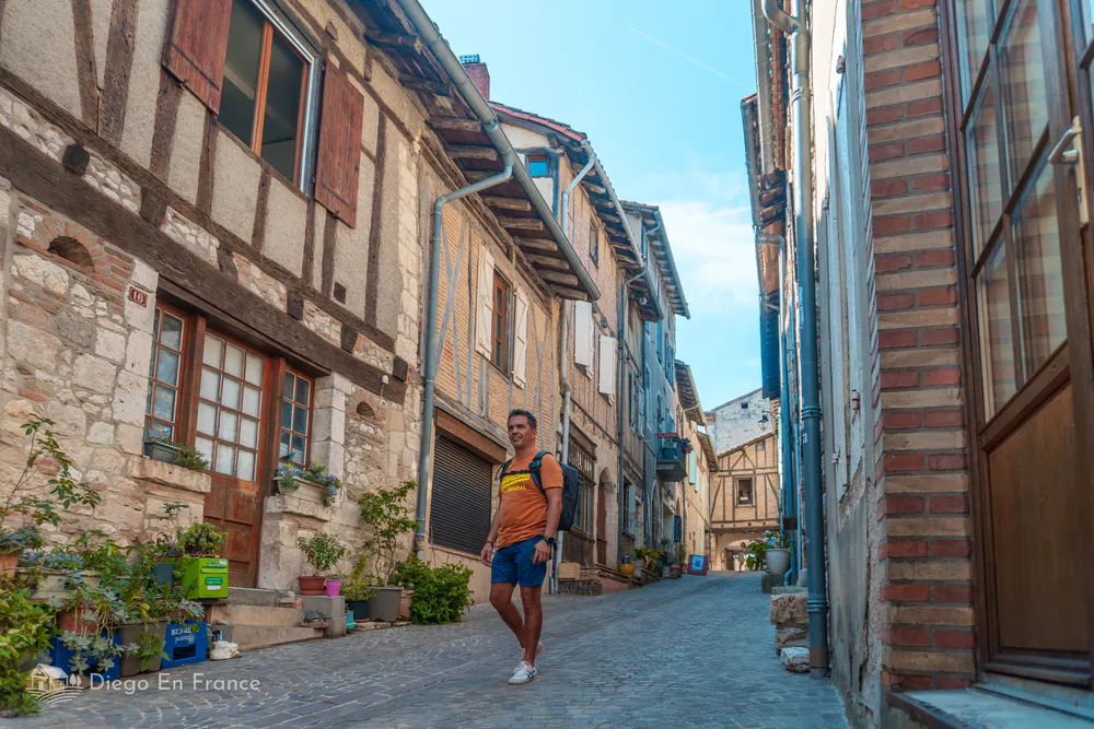 Tourist walking along a medieval street in Castelnau-de-Montmiral, an ideal getaway to discover hidden gems from Toulouse. Photo by diegoenfrance.com
