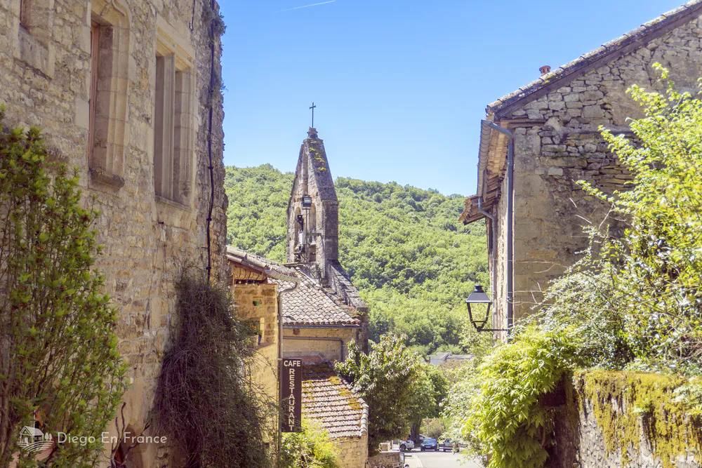 View of Bruniquel’s historic church surrounded by lush countryside and village homes.