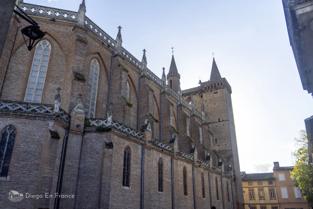 Gothic brick architecture in the church of Saint-Sulpice-la-Pointe with clear sky.