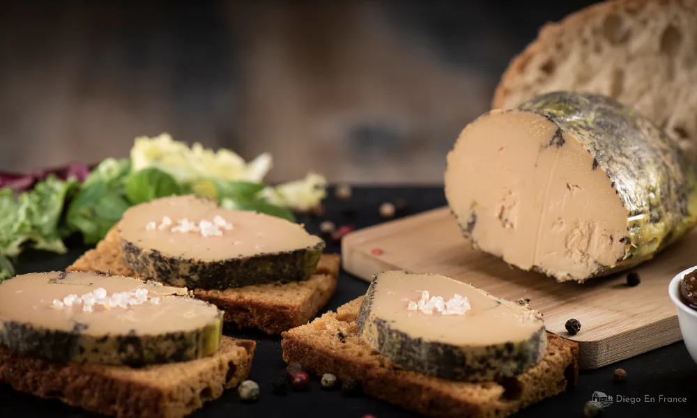 Slices of foie gras on toasted bread with fleur de sel, served with salad and rustic bread.
