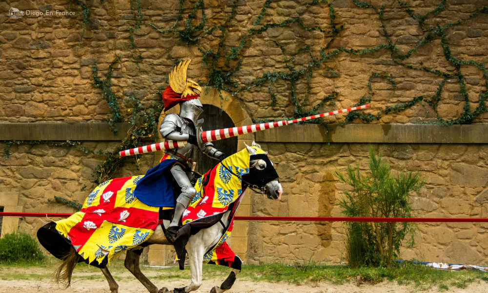 Jousting show at Bruniquel with a costumed rider on horseback in front of the castle wall.