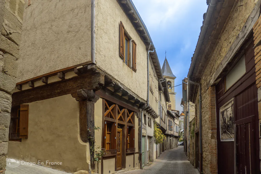 Calle medieval estrecha y pintoresca, con vistas al campanario que marca el ritmo del pueblo.
