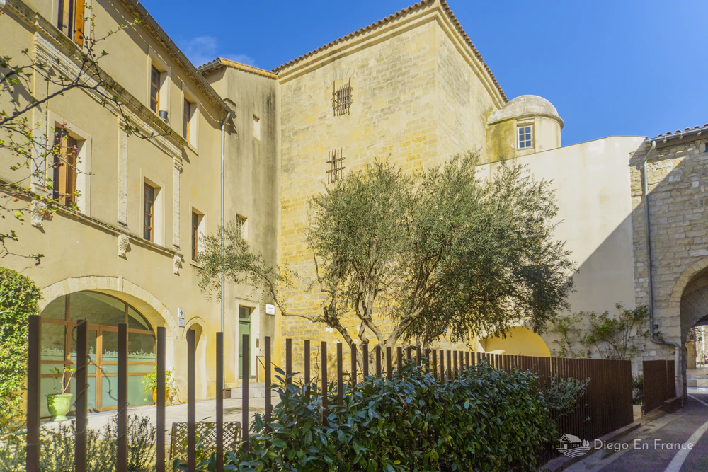 Façade du musée de la Tour des prisons à Lunel, un bâtiment historique avec des murs en pierre et des fenêtres à barreaux. Photo par diegoenfrance.com