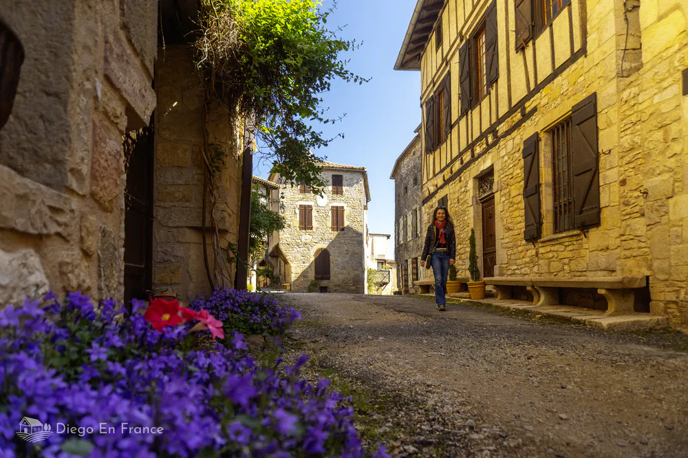 Walk through the old town of Puycelsi, surrounded by flowers, medieval buildings and rural atmosphere.