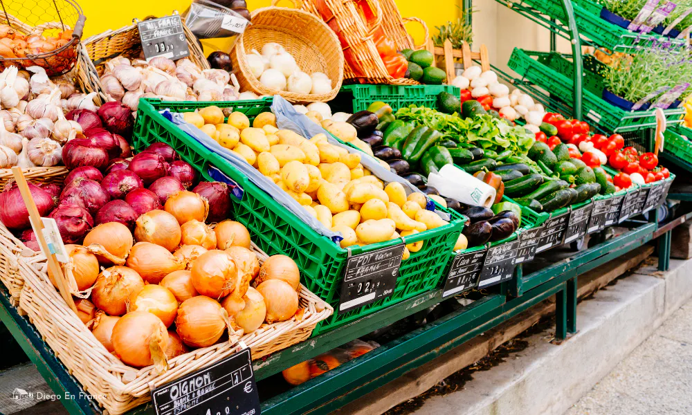 A vibrant display of onions, garlic, potatoes, and vegetables at the Bruniquel farmers’ market.