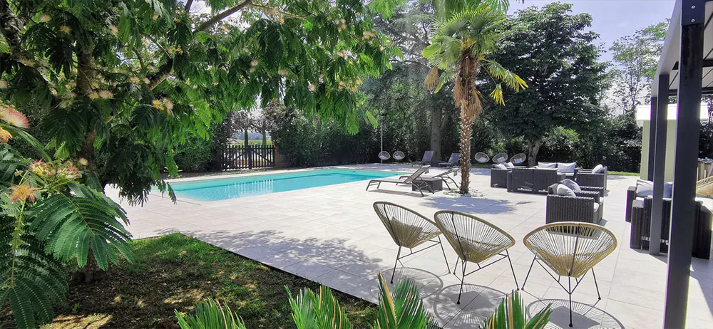 Relaxation area with swimming pool surrounded by greenery at Domaine d'En Fargou, ideal for families.
