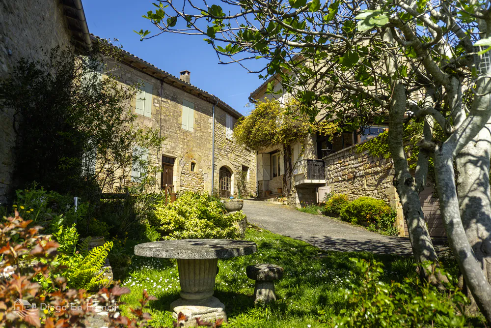 Hidden corner of Puycelsi with manicured gardens and traditional architecture.