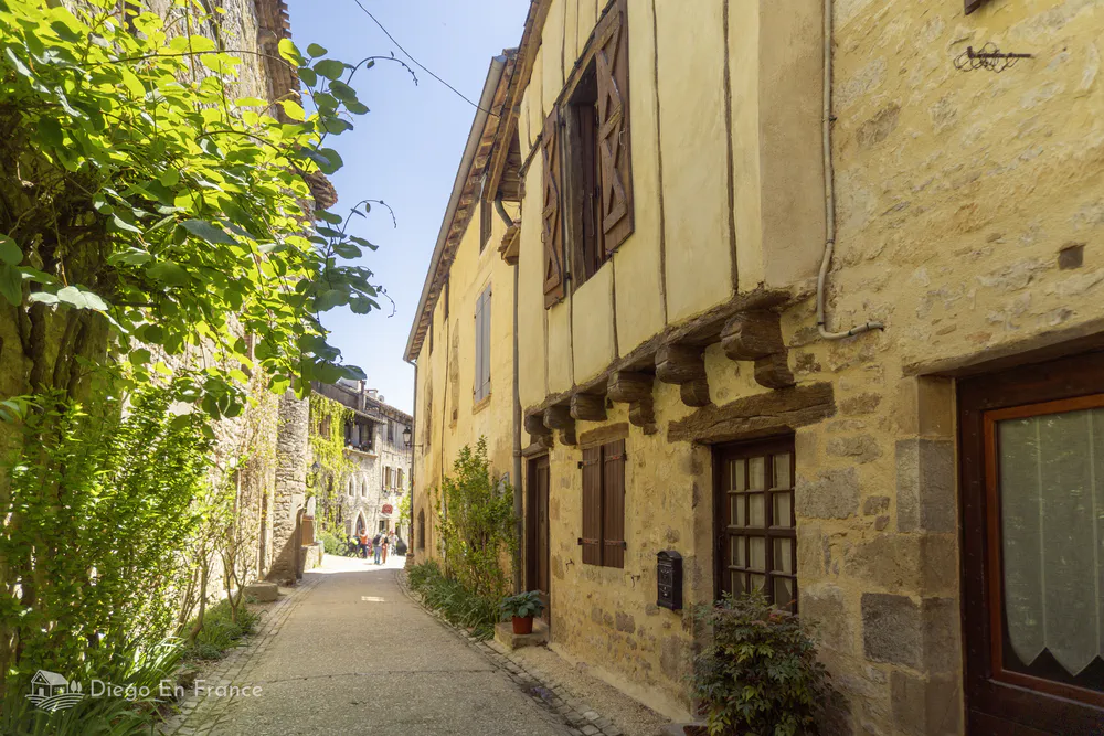 Stone and timber houses lining a quiet street in Bruniquel’s historic village center.
