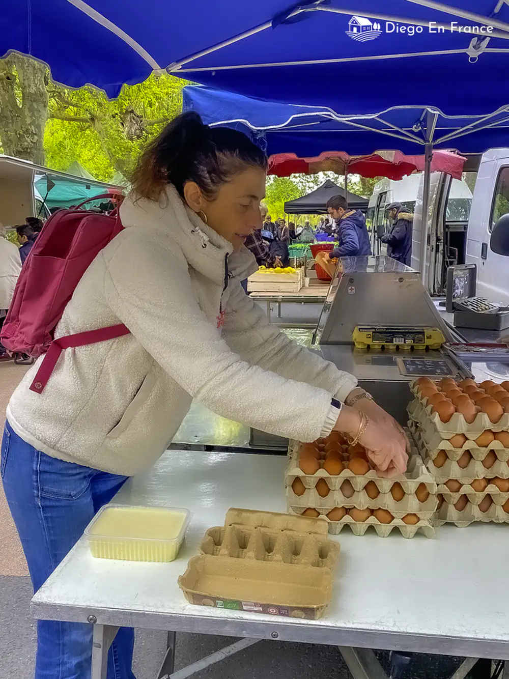 Woman buying eggs at an open-air stall at the Tarn farmers' market.