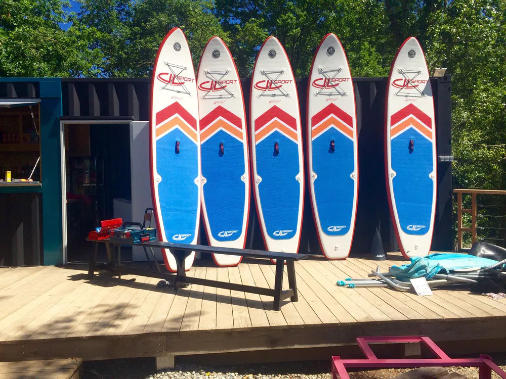 Paddle surf boards in front of a rental hut at Original Green Park, Bessières.