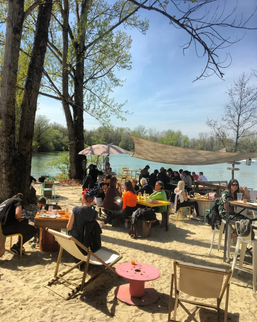 Restoration area in Original Green Park with tables, deck chairs and a view of the water, perfect for families.