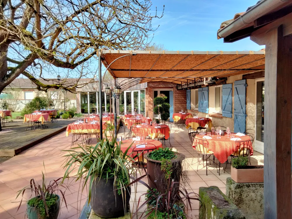 Restaurant Le Colvert in Saint-Lieux-lès-Lavaur with terrace surrounded by greenery and tables ready for service.